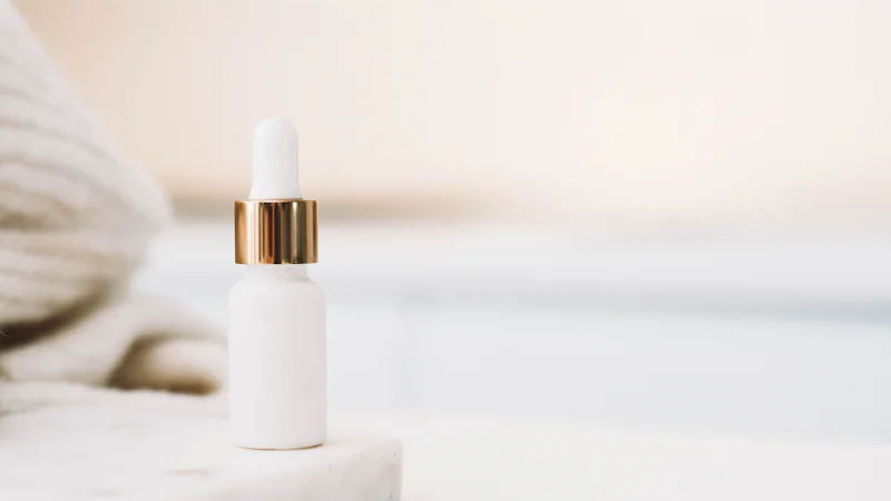 Lọ serum nhỏ giọt màu trắng đặt trên nền sáng, minh họa sản phẩm chứa retinol