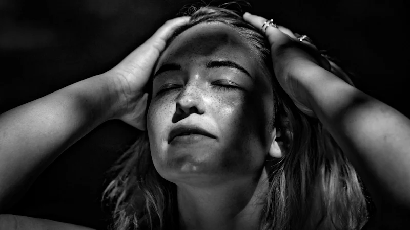 Phụ nữ đưa tay lên đầu khi cơn đau nửa đầu migraine xuất hiện