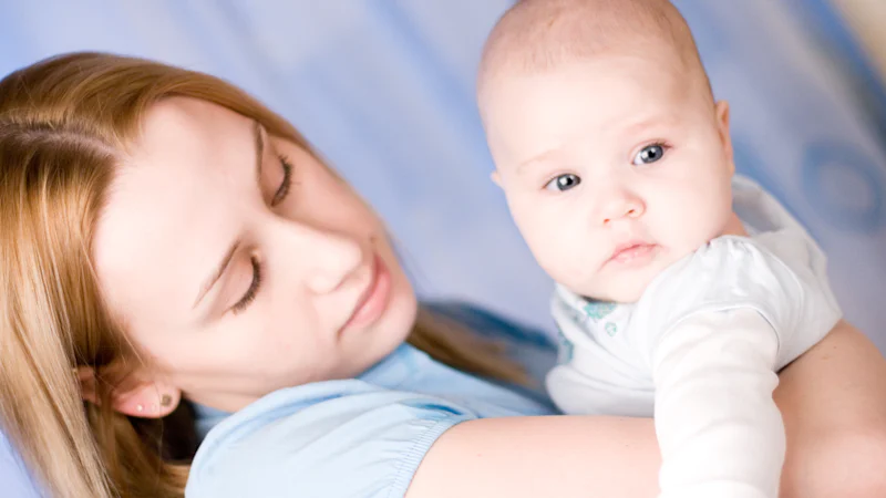 Người mẹ ôm em bé trong vòng tay, minh họa giai đoạn hậu sản sáu tuần đầu